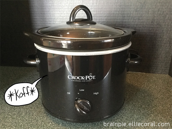 A small black Crockpot makes a cough in a cartoon speech balloon.