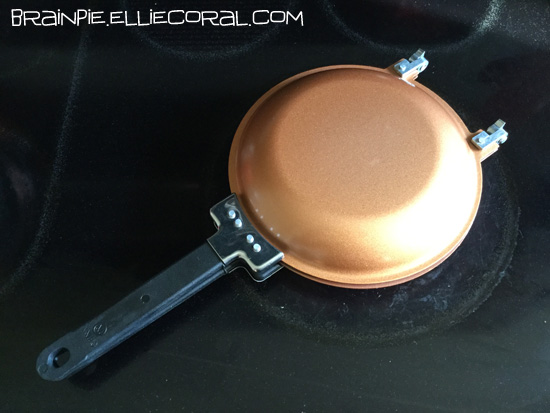 A copper pancake skillet sits on top of a stove.