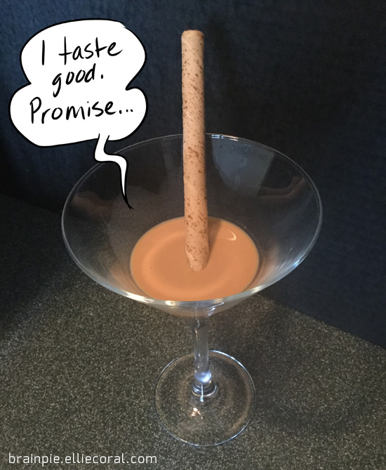 A wafter stick sits in the middle of brown liquid in a martini glass. The stick says, 'I taste good. Promise...'