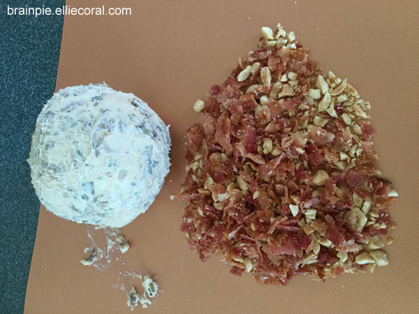 The mixture has somehow been formed into a ball. On the right is the pile of peanuts and bacon crumbles.