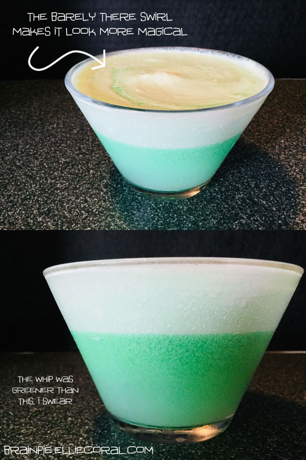 Two views of a triangular puddle glass with a flat bottom seen from a top angle and from the side. The layered liquid is green on the bottom half and white on the top half. The top view has a faint green swirl in the milky froth. A caption reads: The barely there swirl makes it look more magical. For the side view, the caption reads: The whip was greener than this, I swear.