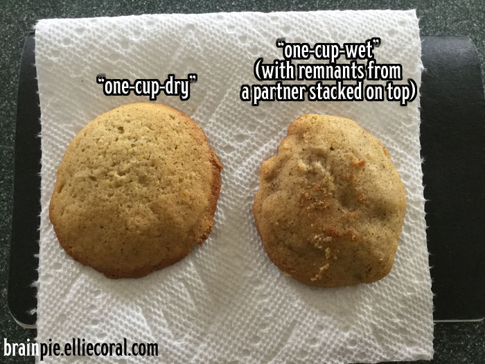 Two flat cookies on a napkin. The one on the left is 'one-cup-dry' and the right one is 'one-cup-wet' (with remnants from a partner stacked on top.