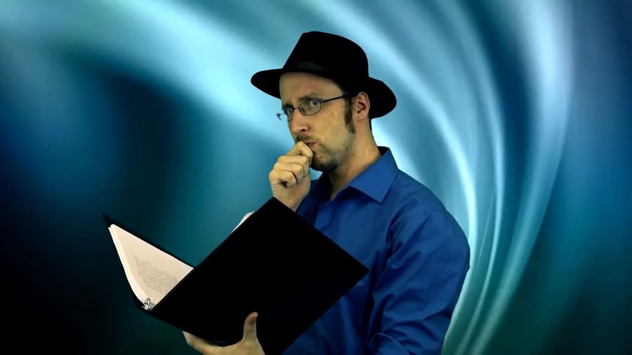 Donnie regards the viewer with a finger curled against his mouth and holding an open binder in the other hand.