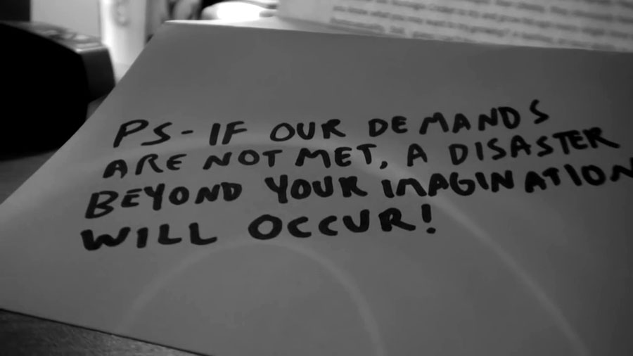 The end of the threatening note. It reads: PS - If our demands are  not met, a disaster beyond your imagination will occur!