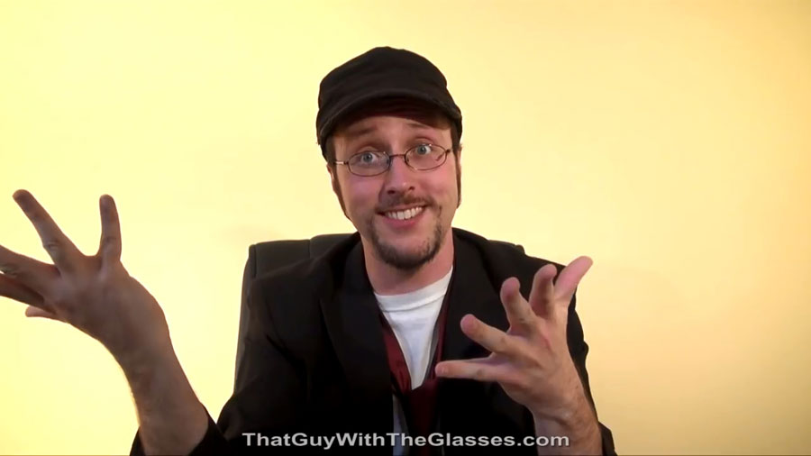 Nostalgia Critic gestures in front of a yellow wall.